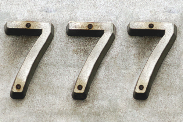 An address with the number 777 riveted to a wall
